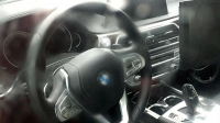 Interiér nového BMW 5 nafocen bez špetky maskování, působí staromilsky
